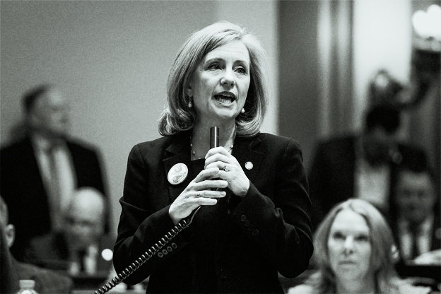 Kristen Robbins holds microphone in Minnesota House chamber